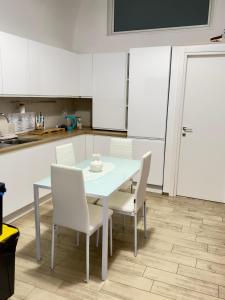 a table and chairs in a kitchen with white cabinets at Dimora Vanni "civico 5" "civico 9" in Polignano a Mare