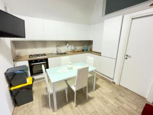 a white kitchen with a table and chairs in it at Dimora Vanni "civico 5" "civico 9" in Polignano a Mare