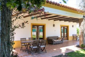 a patio with a table and chairs and a couch at Casa com Piscina Privada em Palmela - Jardim & Estacionamento in Palmela