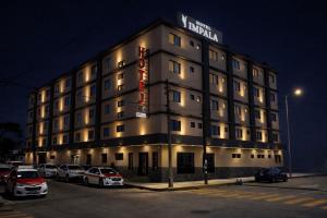 a hotel with cars parked in a parking lot at Hotel Impala Veracruz in Veracruz