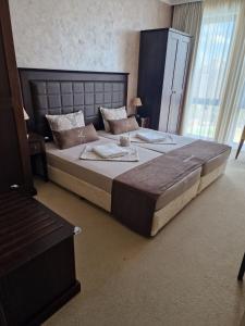 a bedroom with a large bed with a large headboard at Z-apartment in Sunny Beach +2 photos