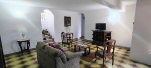a living room with a couch and chairs and a tv at Apartamento dos Arcos in Teresópolis