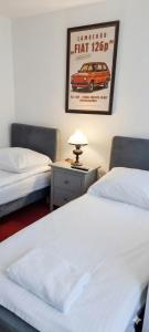a room with two beds and a picture of a car on the wall at Villa Zosieńka - FREE PARKING - Blisko Forum & Stare Miasto in Gdańsk