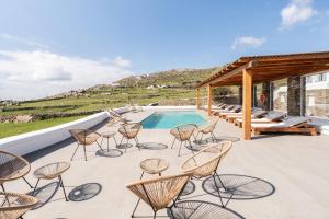 a patio with chairs and a swimming pool at Hillside Collection - by Hospirit in Mikonos