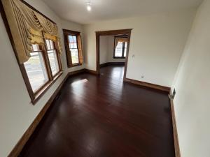 an empty living room with wood floors and windows at Historic 1908 Wamsley House-Completing Renovation! in Hamilton