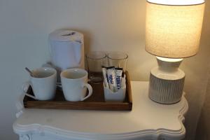 a tray with cups and a lamp on a table at Cranwell Court in Aberystwyth