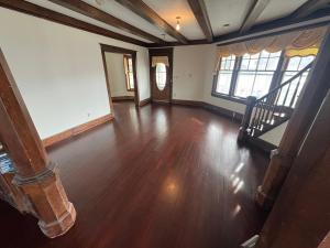 an empty living room with wooden floors and windows at Historic 1908 Wamsley House-Completing Renovation! in Hamilton +1 photo