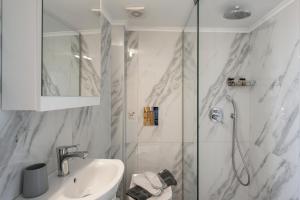 a white bathroom with a shower and a sink at Apartments Chania in Chania +98 photos
