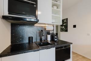 a kitchen with a sink and a microwave at Design-Studio mit Balkon - Nähe Donau in Passau