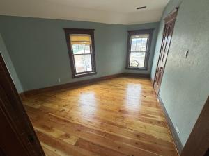 an empty room with two windows and a wooden floor at Historic 1908 Wamsley House-Completing Renovation! in Hamilton