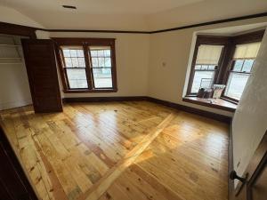 an empty living room with wooden floors and windows at Historic 1908 Wamsley House-Completing Renovation! in Hamilton