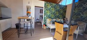 a kitchen and living room with a table and chairs at Refúgio com jacuzzi e vista mar in Estreito da Calheta