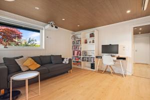 a living room with a couch and a tv at Lykkebo in Stavanger