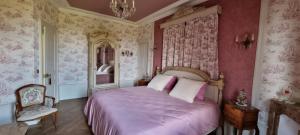 a bedroom with a bed with purple sheets and pink walls at Suite familiale PAMPILLES in Condal +1 photo