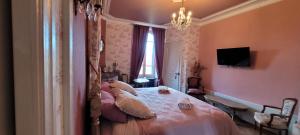 a bedroom with a large bed with a chandelier at Suite familiale PAMPILLES in Condal