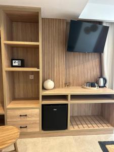 a entertainment center with a flat screen tv on a wall at Starlight Ocean View in Kardamaina