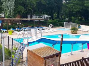 a swimming pool with a slide and chairs and a swimming pool at Chalet avec terrasse - 6 pers. - API-1-52-2172 in Girac