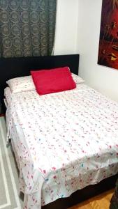 a bed with a red pillow on top of it at Refuge Appartement in Montreal