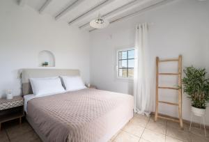 a white bedroom with a bed and a ladder at Hillside Collection - by Hospirit in Mikonos +69 photos