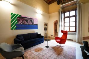 a living room with a blue couch and a red chair at Palazzo Zoya - Elegant Historic Suites - Asti Center - Near Langhe & Monferrato in Asti +88 photos