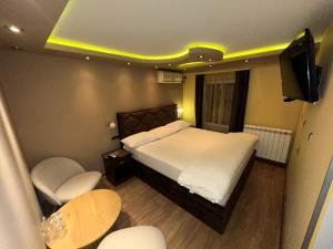 a bedroom with a bed and a tv and a table at Motel Era i Sin in Ba°evac
