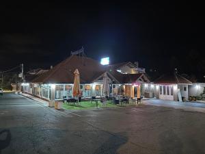 a building with a umbrella and a parking lot at night at Motel Era i Sin in Ba°evac