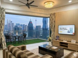 a living room with a tv and a large window at Ehsan Suites in Kuala Lumpur