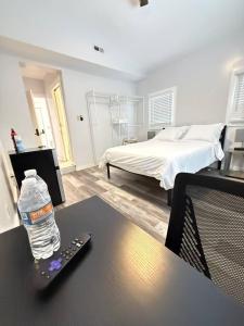 a bottle of water sitting on a table with a remote control at Stay with Jay - Quarta Suite in Cleveland