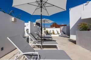 a row of chairs and an umbrella on a patio at Ph and apartments riviera Maya in Playa del Carmen +46 photos