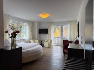 a bedroom with a bed and a living room at Seehotel Lilly in Strobl