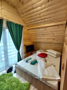 a bedroom with a bed in a wooden room at Cabana MARA in Poiana Vadului