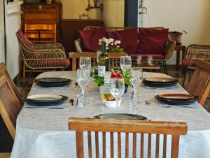 a table with glasses and plates and a bottle of wine at La Kaz 57 - Maison avec jacuzzi et sauna - La Réunion in La Plaine des Palmistes