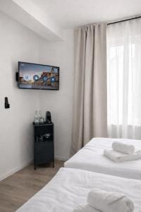 a room with two beds and a tv on the wall at Boutique Hotel Celler Altstadt - 24h Check-in in Celle +15 photos
