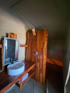 a bathroom with a sink and a tv on a wooden counter at Nature Lovers Camp in Sekenani
