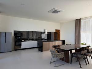 a kitchen with a table and chairs and a refrigerator at Villa luxurious in Koh Samui