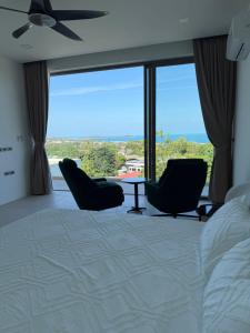 a bedroom with a bed and chairs and a large window at Villa luxurious in Koh Samui +35 photos