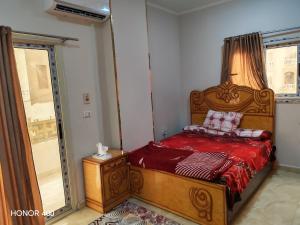 a bedroom with a bed with red sheets and a window at Hurghada Red Sea Apartments in Hurghada