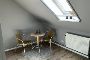 a table and chairs in a room with a window at FewoConny in Hattstedt