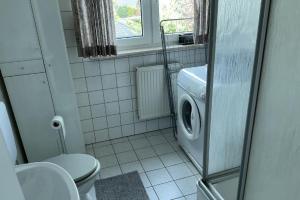 a bathroom with a toilet and a washing machine at FewoConny in Hattstedt