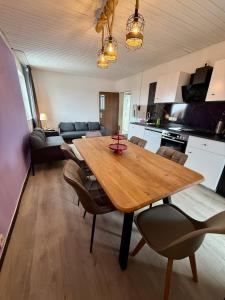 a kitchen and dining room with a wooden table and chairs at Die Schlafstube - Apartments und mehr in Neuharlingersiel