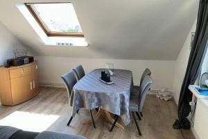 a dining room with a table with chairs and a window at FewoConny in Hattstedt +4 photos