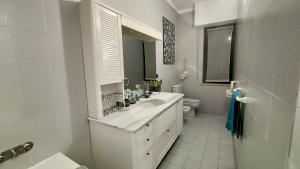 a white bathroom with a sink and a toilet at Casa Mario in Loano