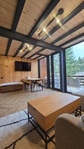 a living room with a table and a tv at Norway Cabins Sinaia Romantic Nordic Escape and Fire Pit in Sinaia
