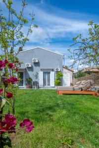 a house with a green yard with a bench at Kallistis Home in Kontokali