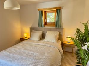 a bedroom with a bed with two lamps and a window at Alpine Home with Lounge - 10 min from St Moritz in La Punt-Chamues-ch +27 photos