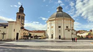 a white building with a clock tower and a church at Casa Mario in Loano