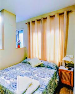 ein Schlafzimmer mit einem Bett und einem Fenster in der Unterkunft ALBOR II in Gijón