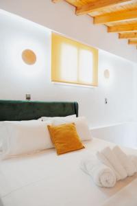 a bedroom with a white bed with a green headboard at Nafos Villa Stella in Levkákia