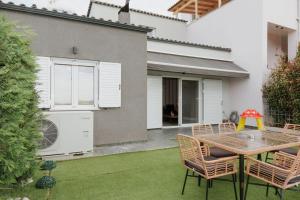 a patio with a table and chairs in front of a house at Nafos Villa Stella in Levkákia