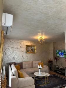 a living room with a couch and a table at Christian Dior Lazarevac in Lazarevac